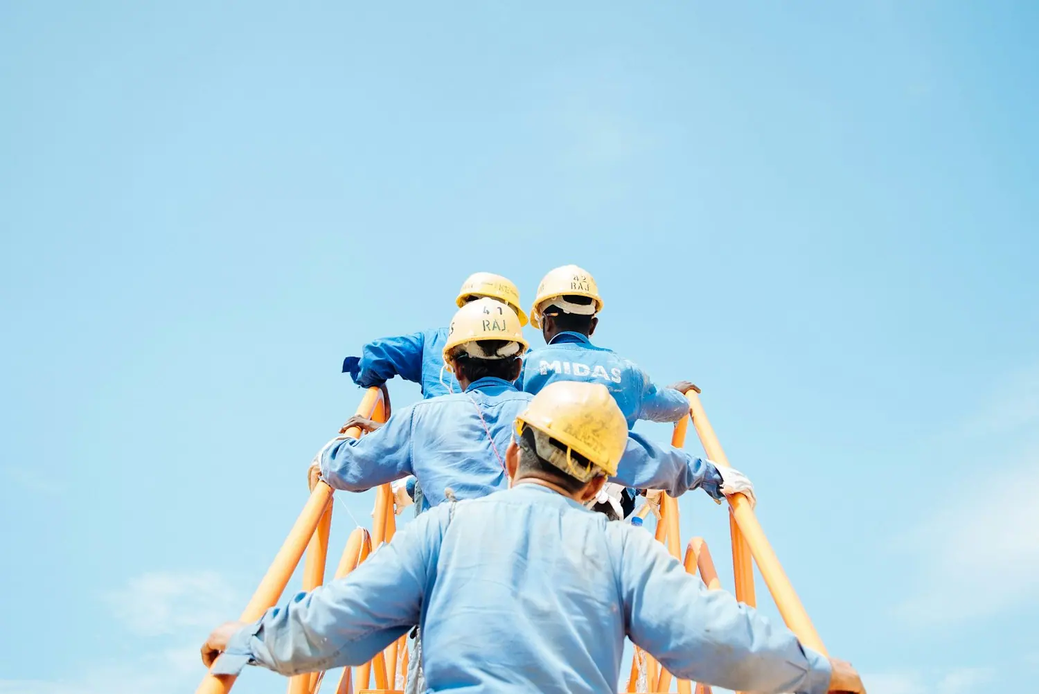 Crew carrying ladders on a commercial job site
